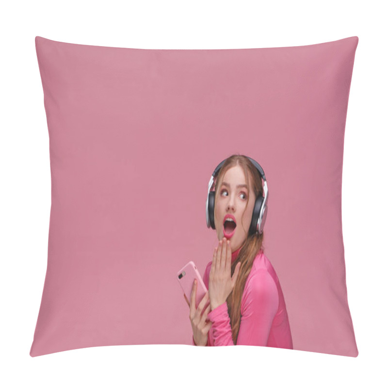 Personality  Funny Surprised Redhead Girl Holding Mobile Phone Waiting For Messages And Congratulations From Friends. Young Smiling Woman Wearing Earphones Holding Smartphone Over Pink Background. Copy Space Pillow Covers