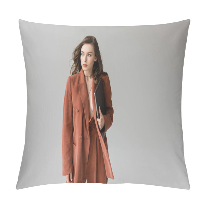 Personality  Brunette Young Woman With Long Hair And Necklace Wearing Terracotta Trendy Suit With Blazer And Pants, Holding Laptop While Standing On Grey Background, Freelancer, Remote Work, Looking Away Pillow Covers