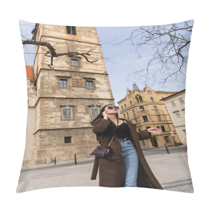 Personality  Trendy young woman in coat and sunglasses walking on urban street in Prague  pillow covers