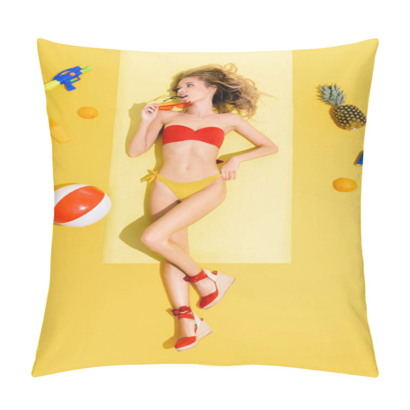 Personality  Top View Of Young Woman Holding Eyeglasses While Lying On Beach Mat Near Fruits, Inflatable Ball, Water Gun And Sunscreen On Yellow Pillow Covers