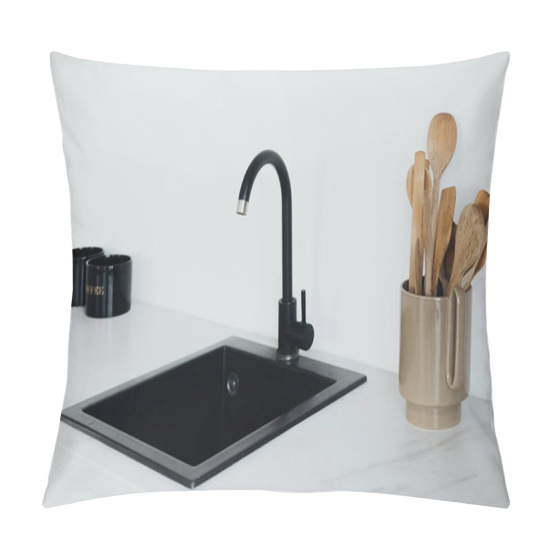 Personality  A Sleek Black Sink Is Paired With A Stylish Faucet, While Wooden Utensils Rest In A Chic Container On The Marble Countertop, Creating A Contemporary Kitchen Atmosphere. Pillow Covers