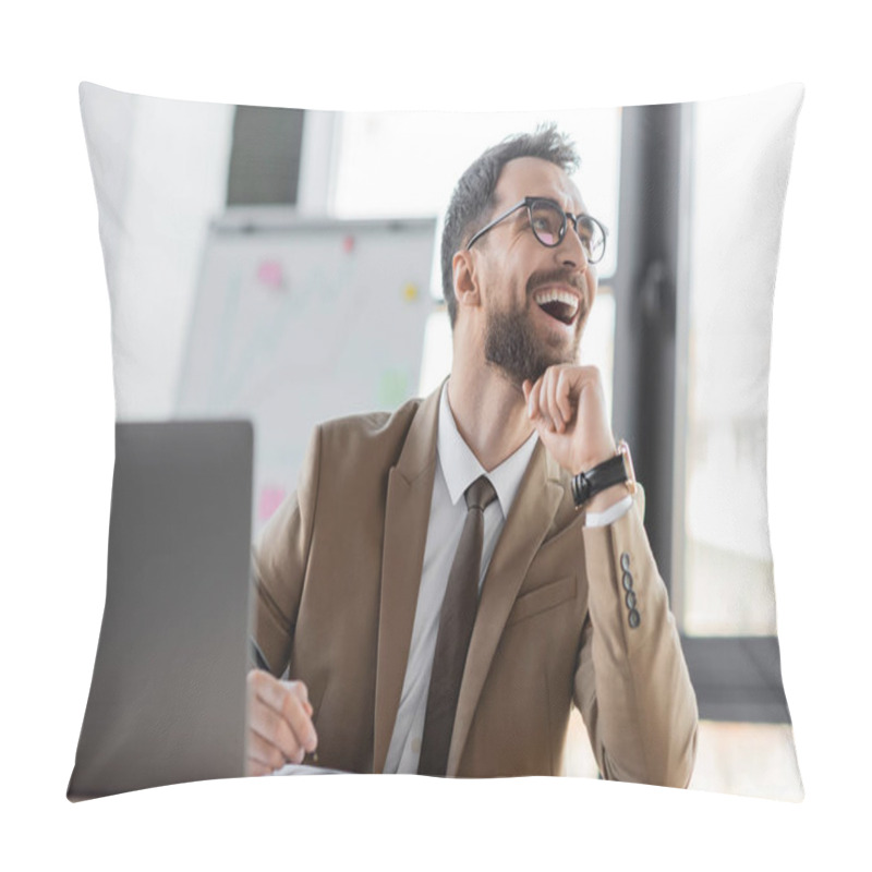 Personality  Overjoyed And Stylish Businessman In Beige Blazer, Tie And Eyeglasses Sitting At Workplace With Pen And Notebook Near Laptop, Laughing And Looking Away In Office Pillow Covers