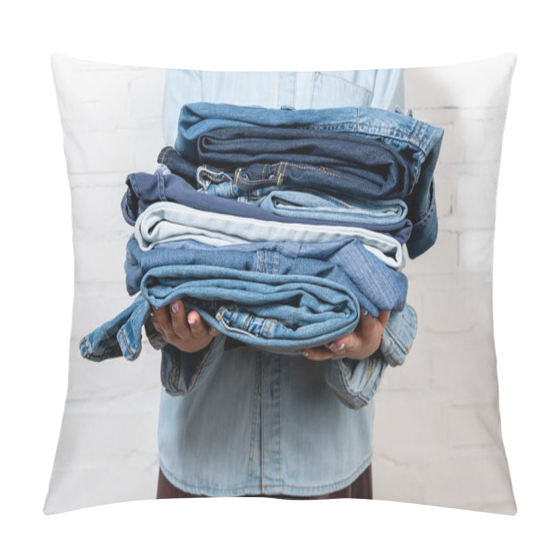 Personality  Cropped View Of Woman Holding Stack Of Blue Denim Clothes Near White Brick Wall Pillow Covers