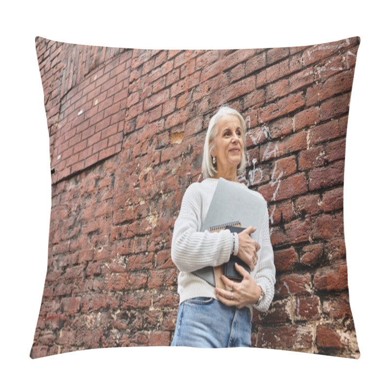 Personality  A Mature Woman With Gray Hair Embraces A Notebook While Standing Outdoors, Smiling Gently. Pillow Covers