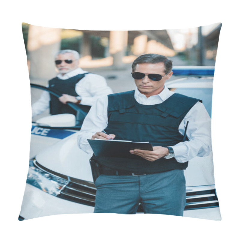 Personality  Male Police Officer In Sunglasses Writing In Clipboard While His Colleague Standing Near Car At Street Pillow Covers