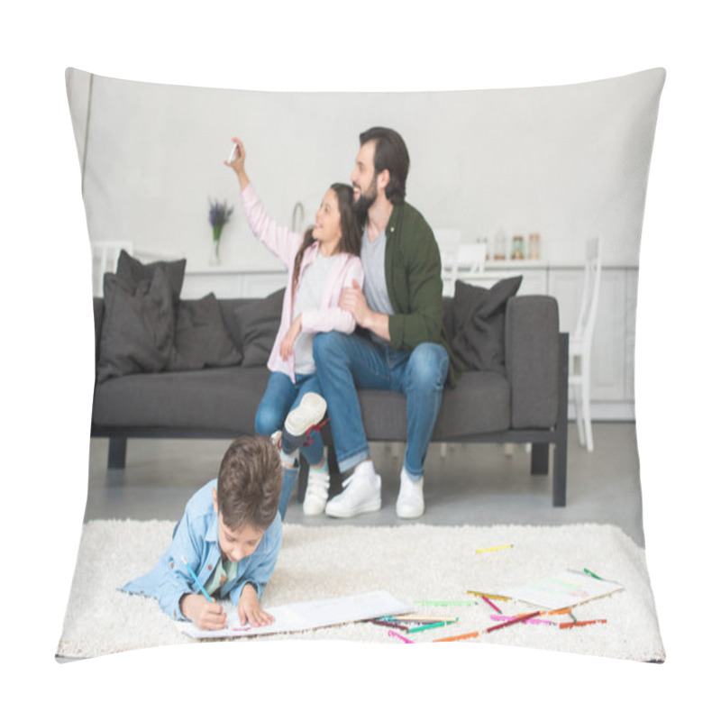 Personality  Happy Father And Daughter Sitting On Sofa And Taking Selfie With Smartphone While Little Boy Drawing On Carpet At Home Pillow Covers