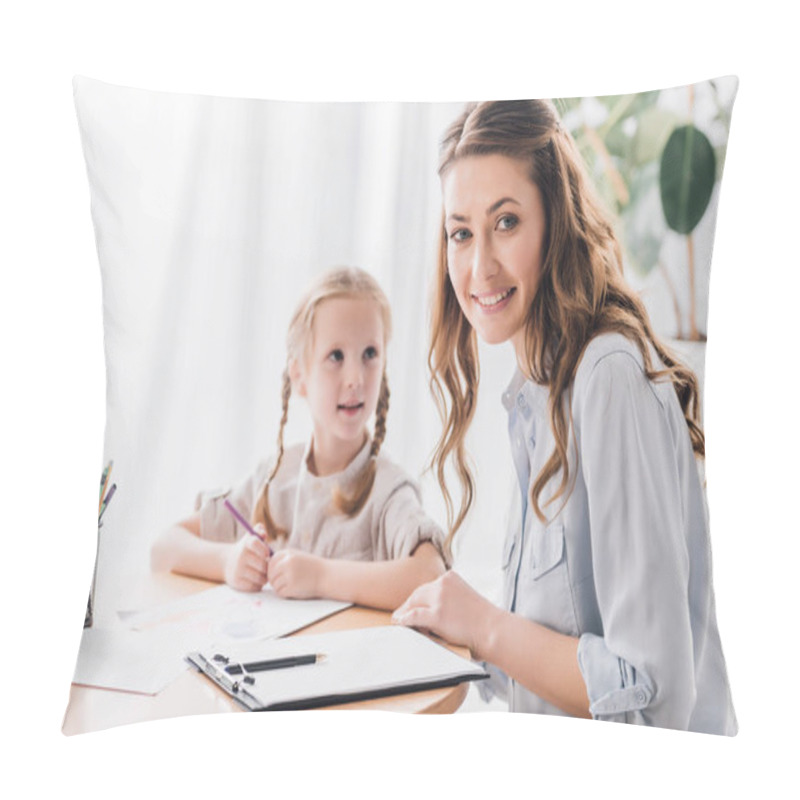 Personality  Smiling Psychologist With Clipboard Sitting Near Little Child While She Drawing With Color Pencils And Looking At Camera Pillow Covers