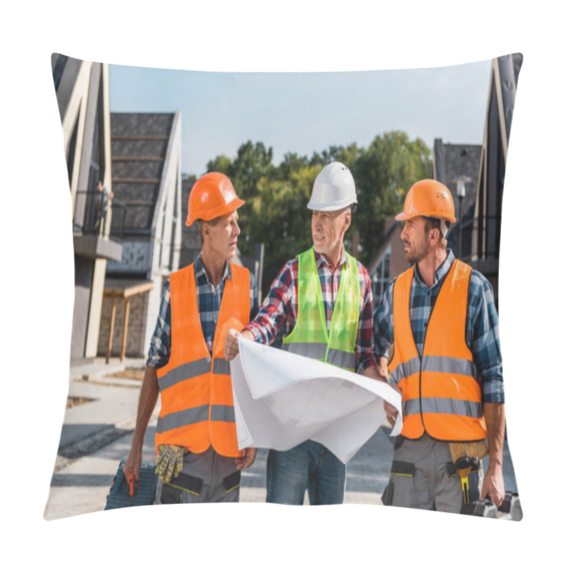 Personality  Mature Builder Holding Blueprint Near Coworkers And Houses  Pillow Covers