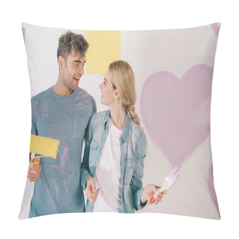 Personality  Happy Young Couple Looking At Each Other While Standing Near Pink Heart Painted On White Wall Pillow Covers