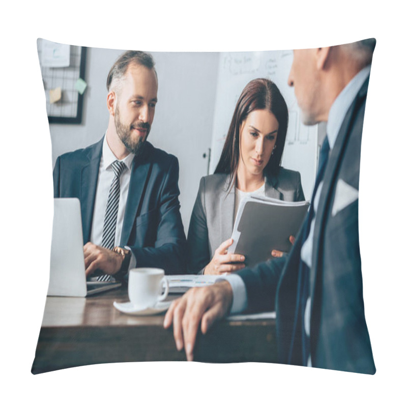 Personality  Smiling Businessman With Laptop Sitting Near Colleague With Paper Folder And Investor On Blurred Foreground In Office  Pillow Covers