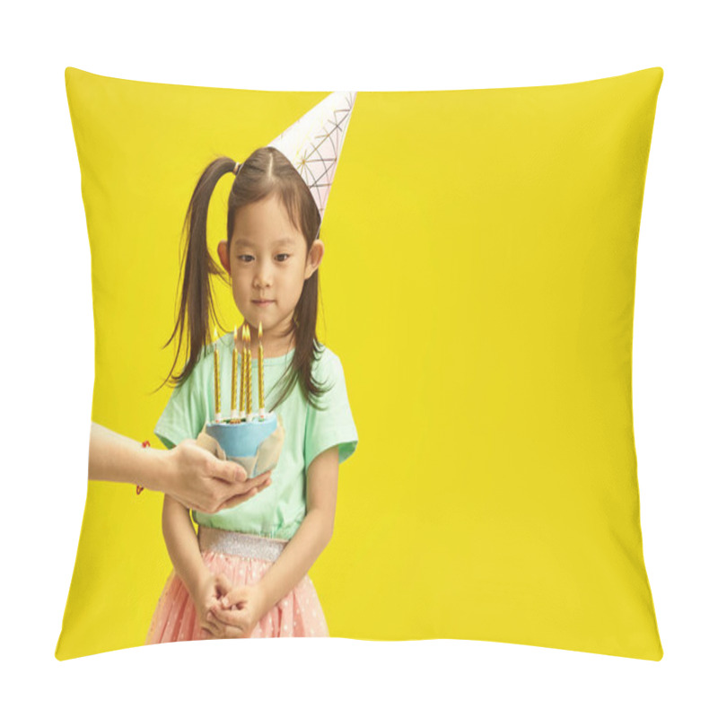 Personality  Studio Portrait Of Korean Child Girl In Party Conical Hat Focused Stands In Front Of A Cake With Candles Held By Adult Hands, Make A Wish, Is Going To Blow Out The Candles Standing On Yellow Isolated Pillow Covers