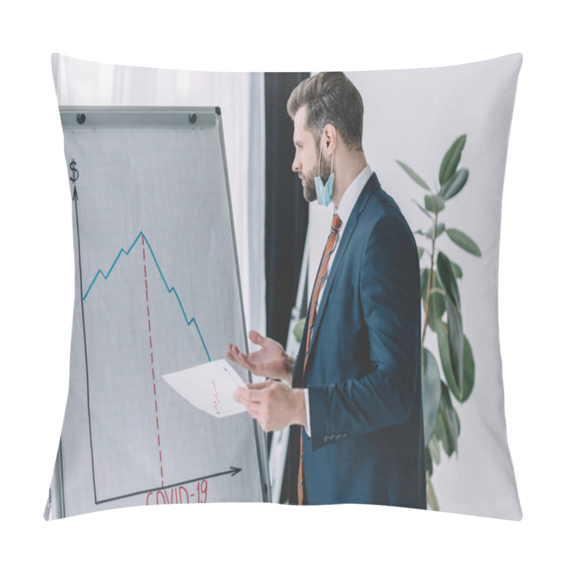 Personality  Serious, Thoughtful Businessman Holding Paper While Standing At Flipchart With Graphs Showing Decrease Pillow Covers