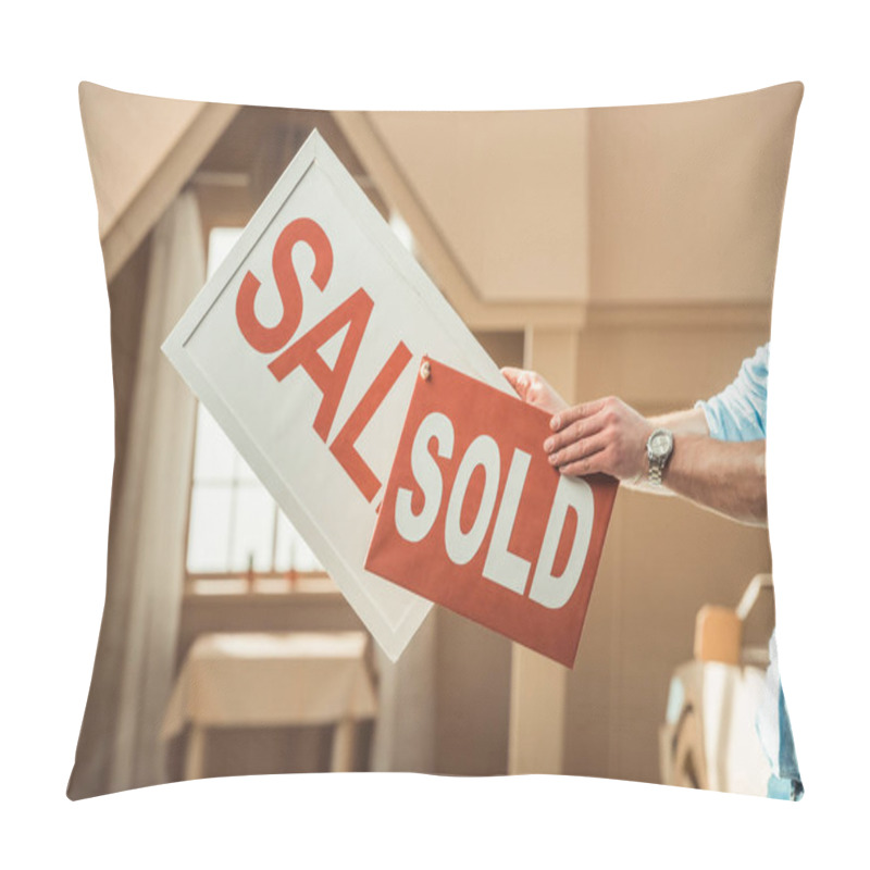 Personality  Cropped Shot Of Man Holding Sale And Sold Signboards In Front Of Cardboard House Pillow Covers