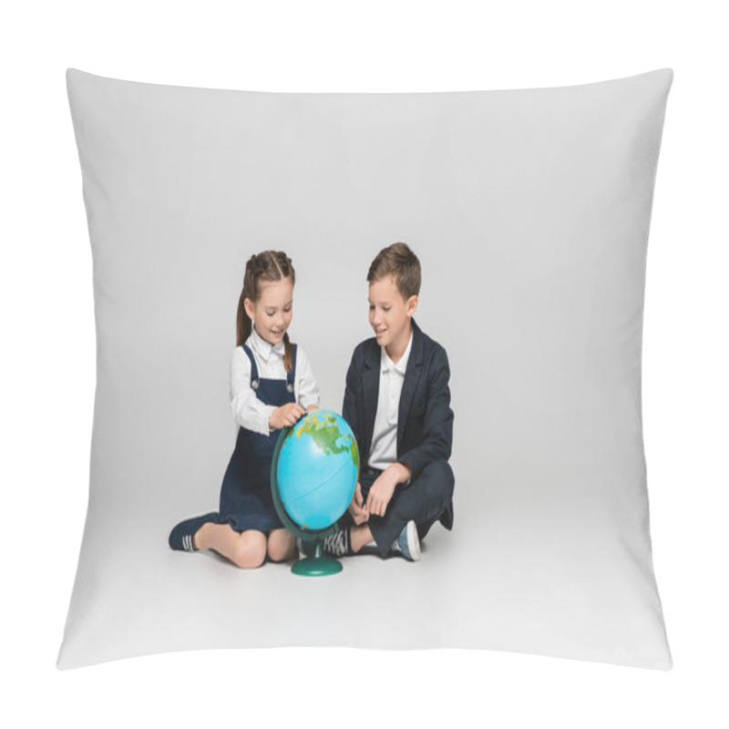 Personality  Happy Schoolgirl And Schoolboy Looking At Globe While Sitting On Grey Pillow Covers