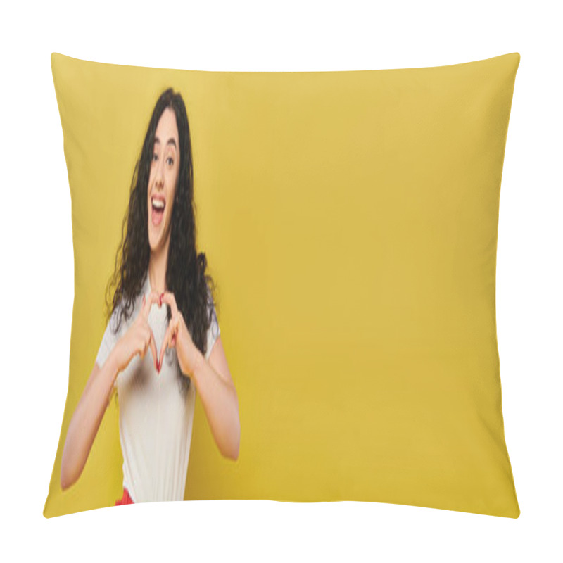 Personality  Young, Curly-haired Brunette Woman In Chic Attire, Forming Heart Shape With Her Hands Against Vibrant Yellow Backdrop. Pillow Covers