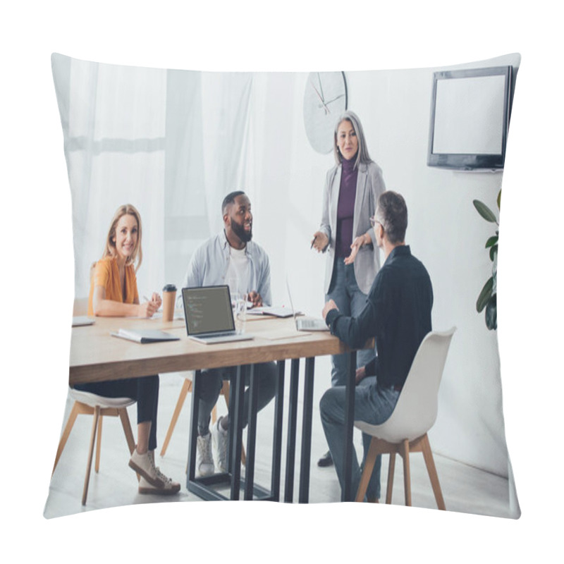 Personality  KYIV, UKRAINE - DECEMBER 6, 2019: Smiling Multicultural Colleagues Talking With Asian Businesswoman Near Laptop With Html Code  Pillow Covers