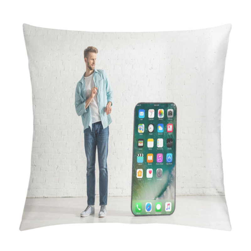 Personality  KYIV, UKRAINE - FEBRUARY 21, 2020: Scared Man Looking At Big Model Of Smartphone With Iphone Screen At Home  Pillow Covers