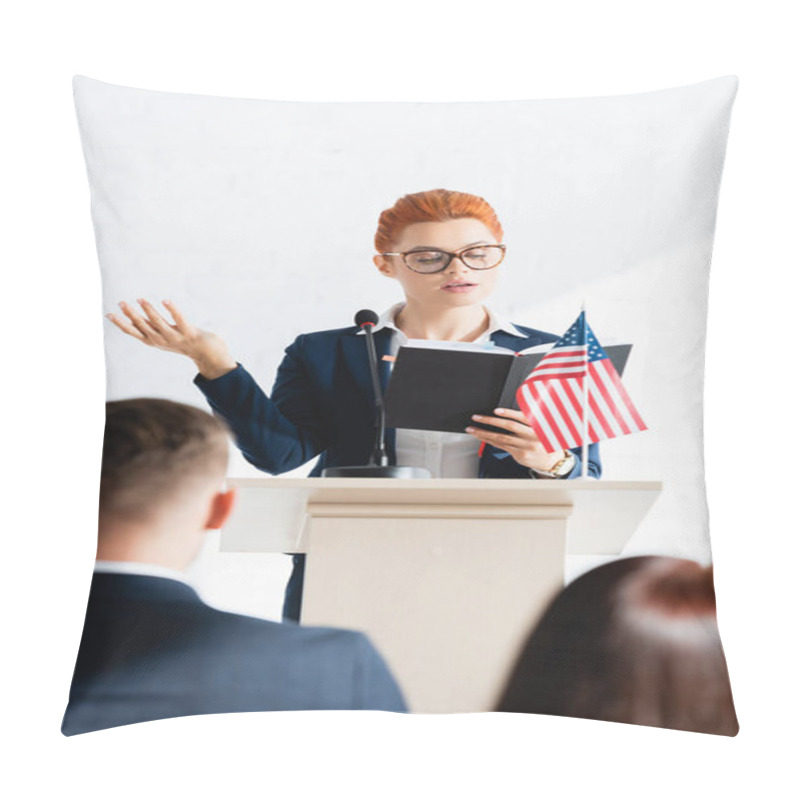 Personality  Speaker Looking At Notebook And Gesturing In Front Of Voters In Conference Room, Blurred Foreground Pillow Covers