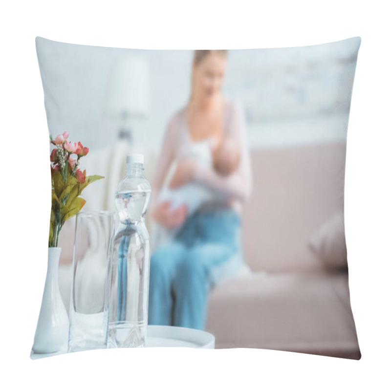 Personality  Close-up View Of Glass, Bottle Of Water, Flowers In Vase And Mother Breastfeeding Baby Behind At Home Pillow Covers