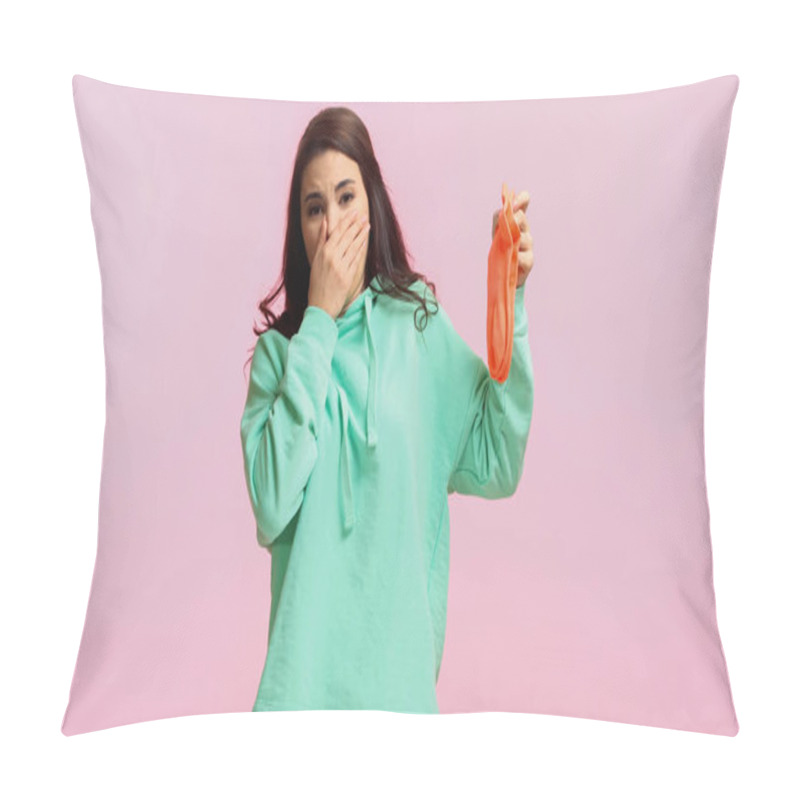 Personality  Young And Brunette Woman In Turquoise Hoodie Plugging Nose While Holding Stinky Socks Isolated On Pink  Pillow Covers