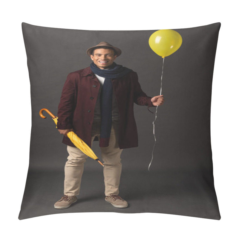 Personality  Smiling Mixed Race Man In Scarf And Hat Holding Yellow Balloon And Umbrella On Black Background Pillow Covers