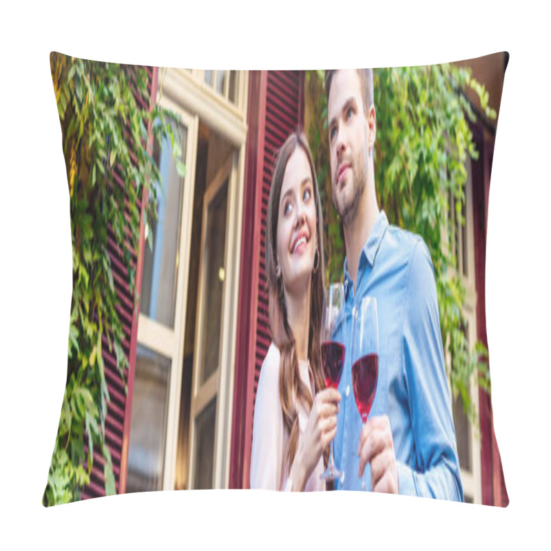 Personality  Panoramic Shot Of Happy Couple Holding Glasses Of Red Wine While Standing Near House Covered With Green Ivy Pillow Covers