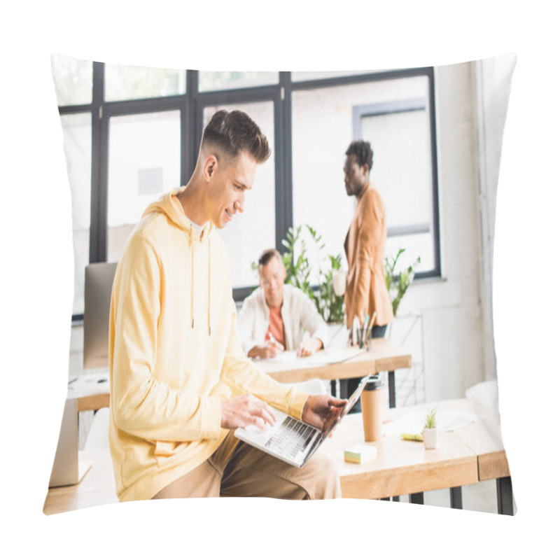 Personality  Young Businessman Using Laptop While Sitting On Desk In Office Near Multicultural Colleagues Pillow Covers