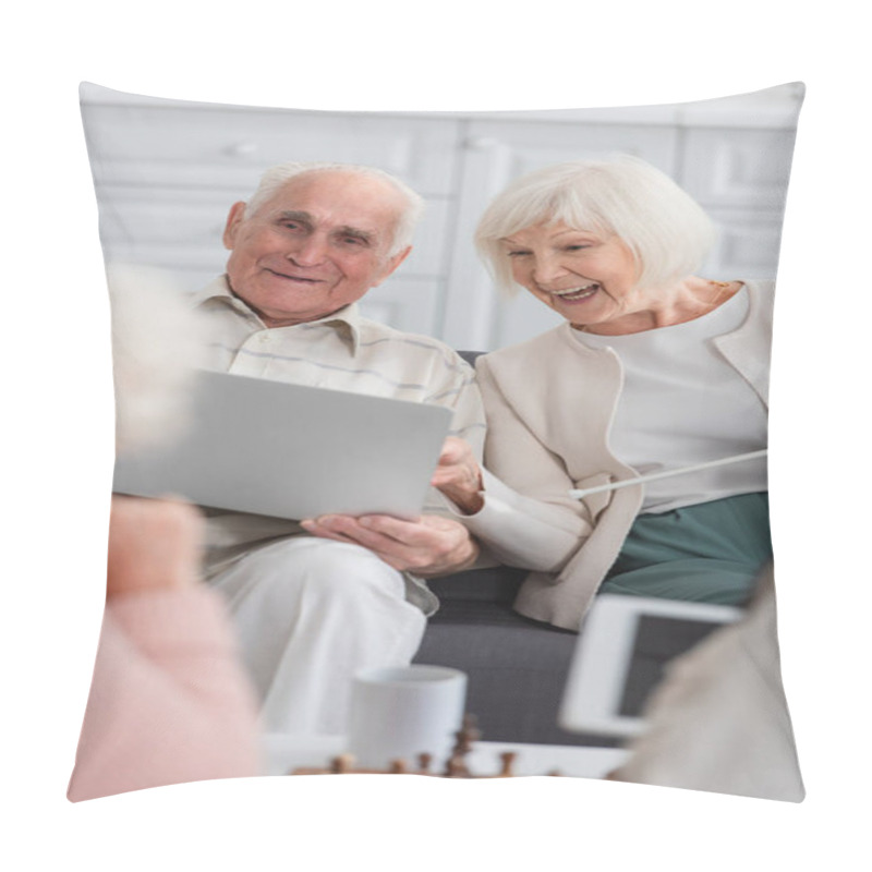 Personality  Positive Senior Woman With Yarn Looking At Laptop Near Friend And Blurred Chess In Nursing Home  Pillow Covers