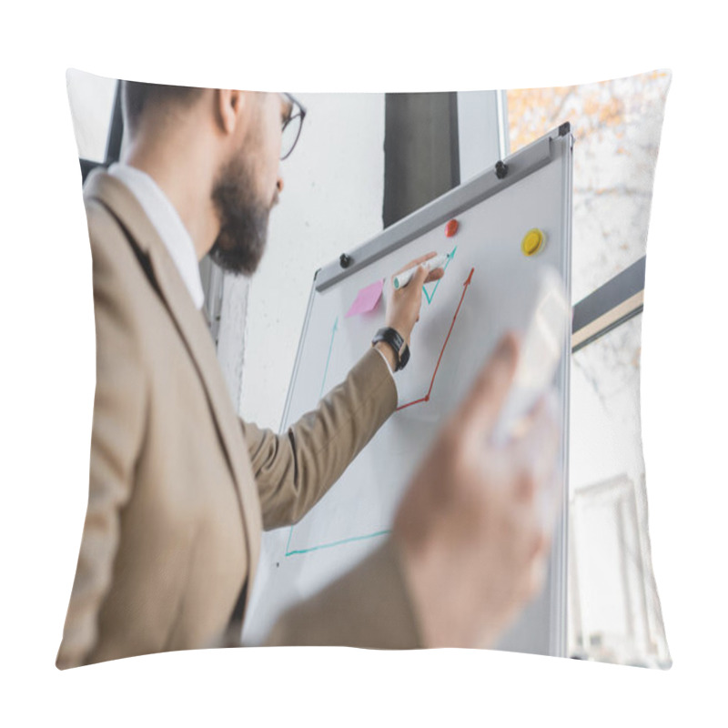 Personality  Low Angle View Of Bearded Businessman In Beige Blazer Holding Blurred Smartphone And Drawing Graphs On Flip Chart While Making Business Analytics In Office Pillow Covers