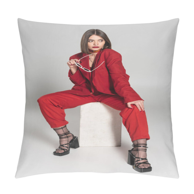 Personality  Fashion Model With Brunette Short Hair And Nose Piercing Posing In Red Suit While Holding Sunglasses And Sitting On Concrete Cube On Grey Background, Lady In Red, Young Woman, Fashion Trend  Pillow Covers