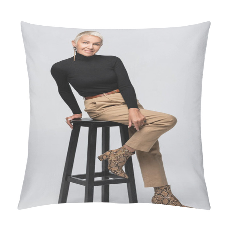 Personality  Full Length Of Cheerful Senior Woman In Beige Pants And Turtleneck Sitting On Chair On Grey Pillow Covers