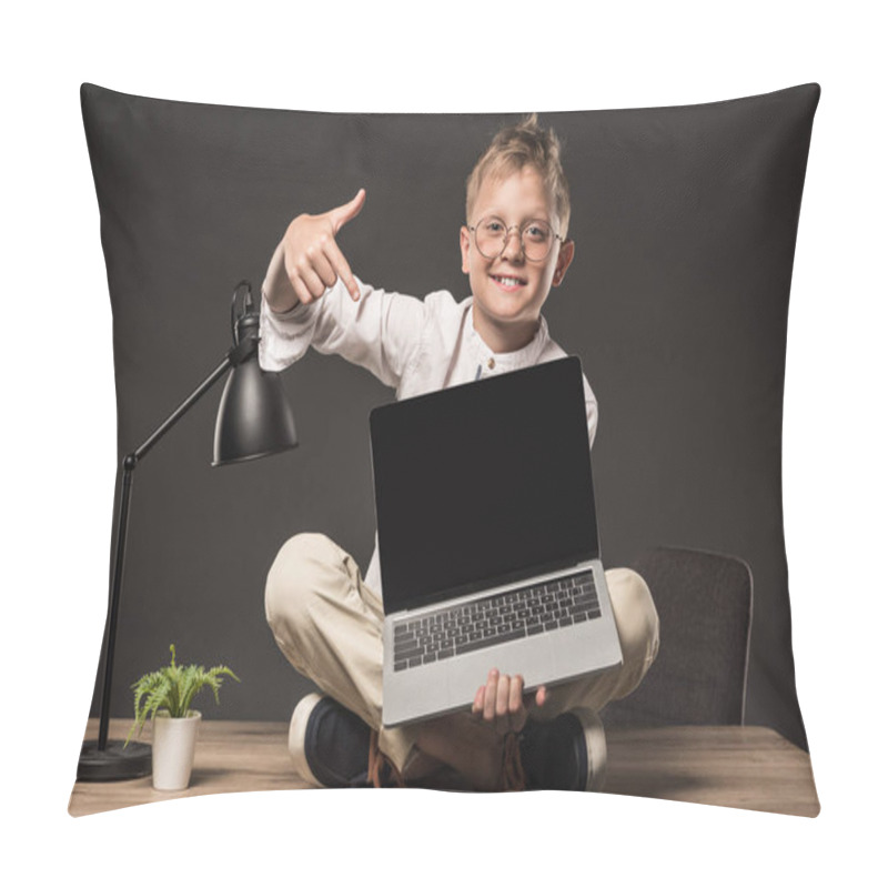 Personality  Smiling Little Boy In Eyeglasses Sitting On Table And Pointing On Laptop With Blank Screen On Grey Background  Pillow Covers