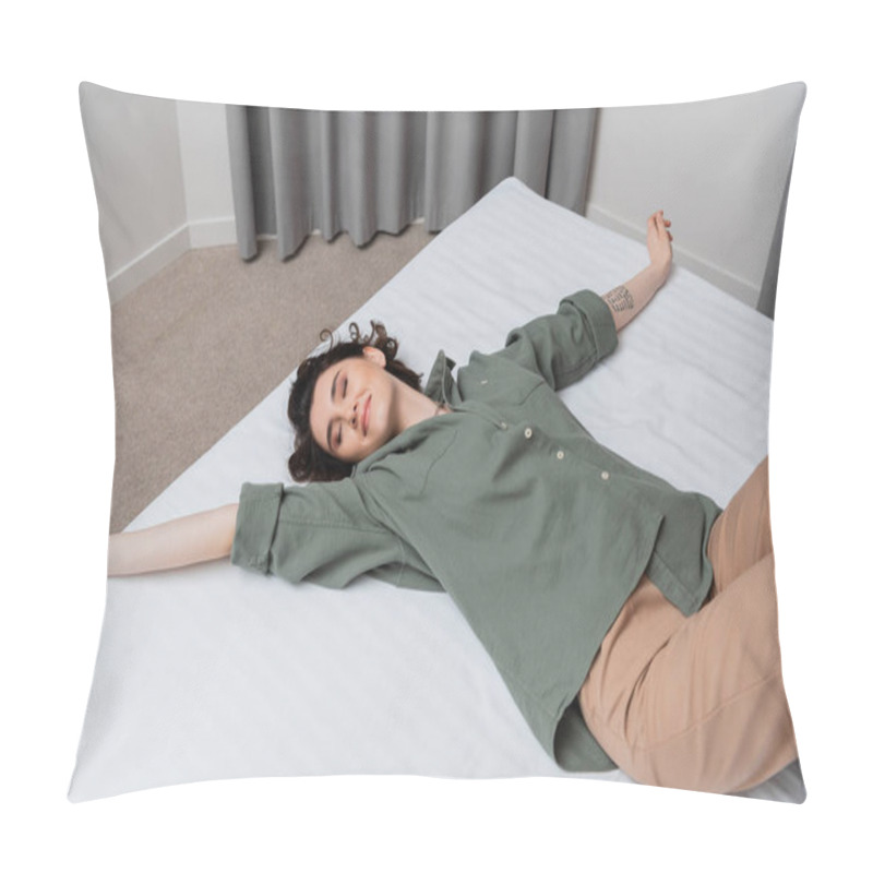 Personality  High Angle View Of Young And Carefree Woman With Wavy Brunette Hair, Tattoo And Closed Eyes Smiling While Lying On Bed In Casual Clothes In Modern And Cozy Hotel Suite, Leisure And Travel Pillow Covers