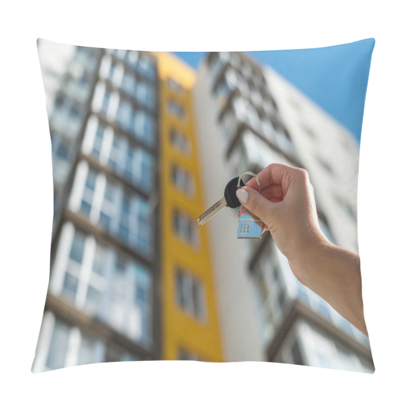 Personality  Key To The House In The Hands Of A Woman Against The Background Of A New Apartment Building. Real Estate Concept Pillow Covers