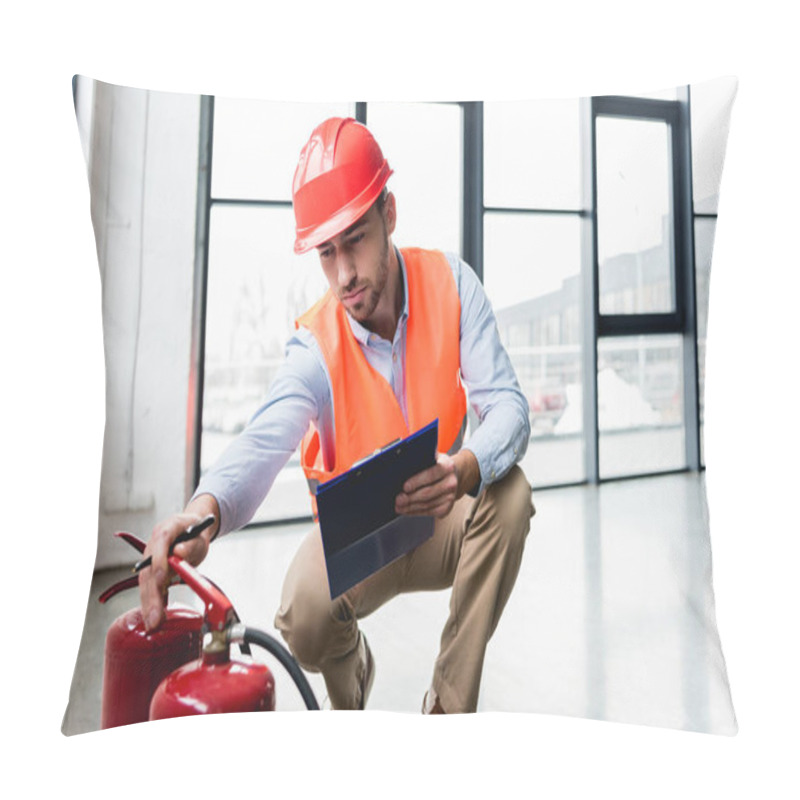 Personality  Serious Fireman In Helmet Checking Extinguishers While Sitting With Clipboard Pillow Covers