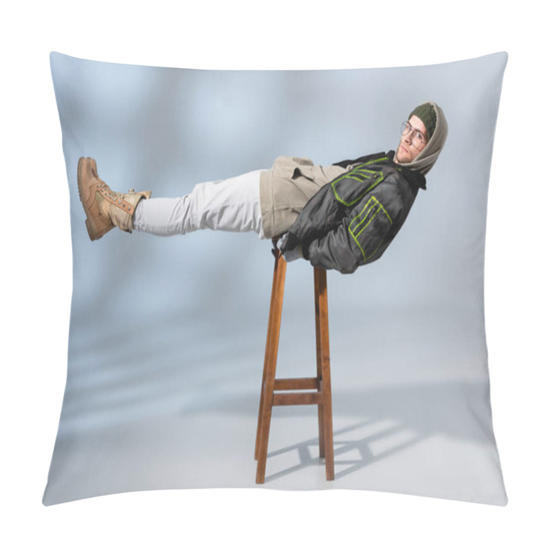 Personality  Young Trendy Man In Hat And Anorak Lying Horizontally On Wooden Stool On Grey  Pillow Covers