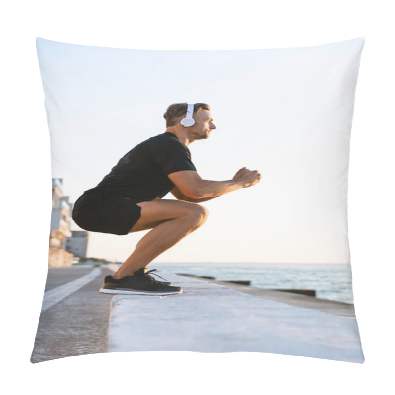 Personality  Side View Of Athletic Adult Man In Headphones Standing Squats On Parapet On Seashore Pillow Covers