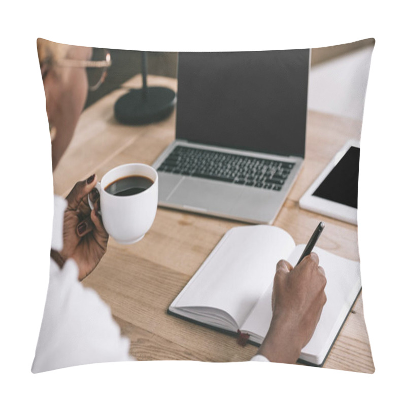 Personality  Cropped View Of African American Woman Writing In Notebook And Holding Cup With Coffee Near Laptop With Blank Screen  Pillow Covers