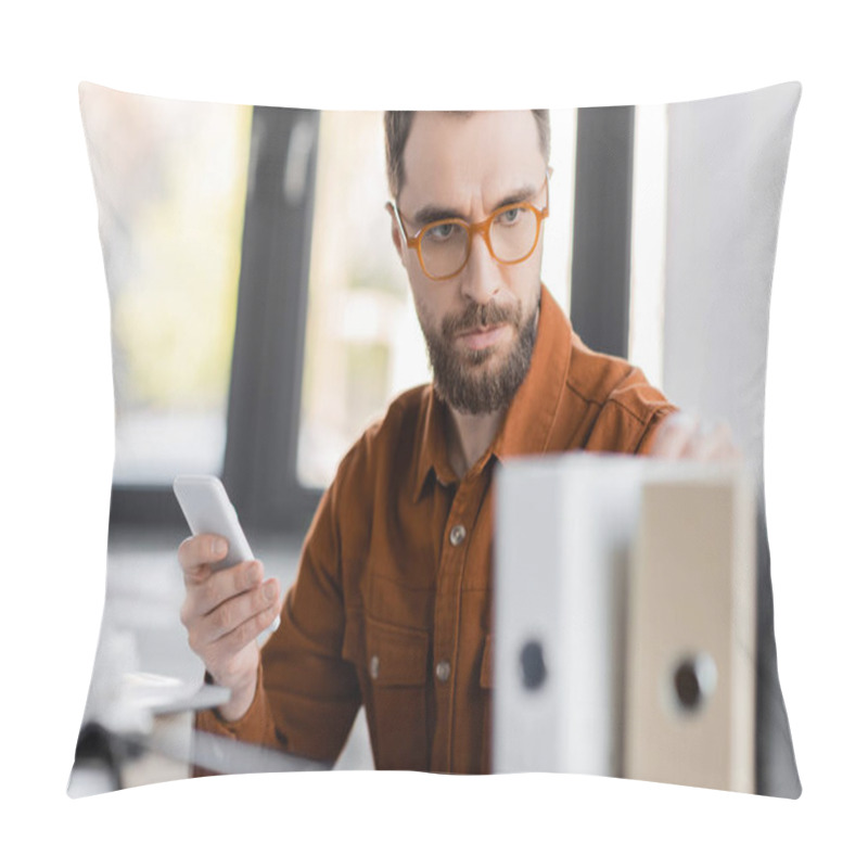 Personality  Concentrated And Serious Businessman In Stylish Eyeglasses And Shirt Holding Mobile Phone And Looking At Blurred Folders While Working On Business Productivity In Office Pillow Covers