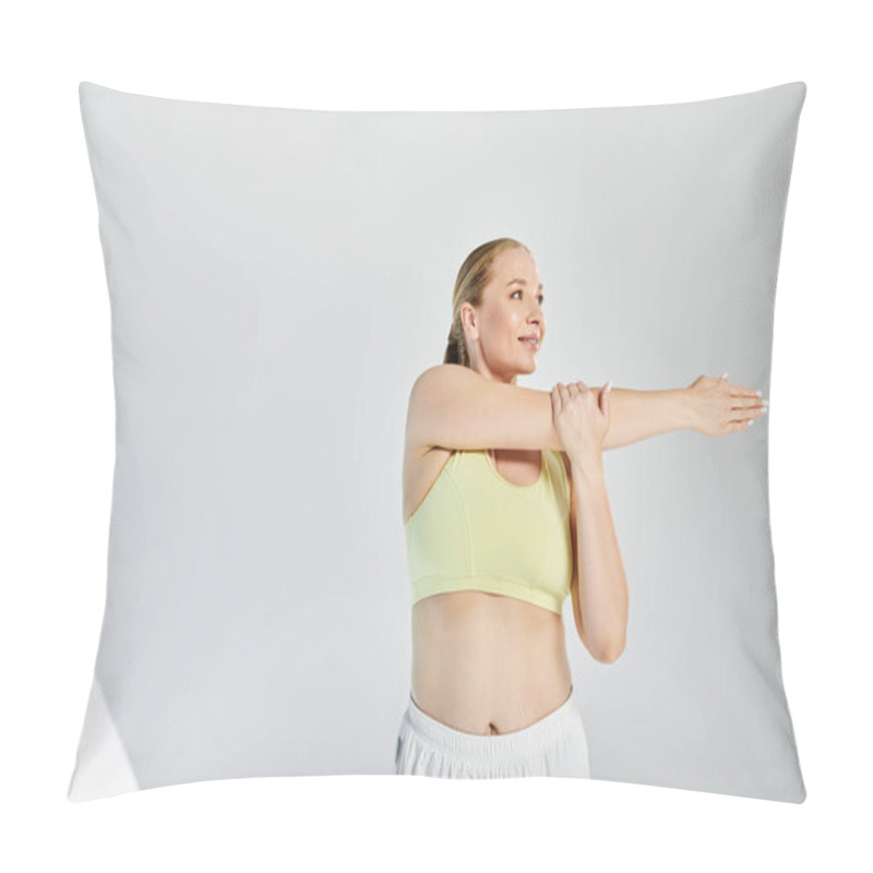 Personality  A Fit Woman In A Crop Top Stretches Her Arms In A Vibrant Studio, Showcasing Her Commitment To Health. Pillow Covers