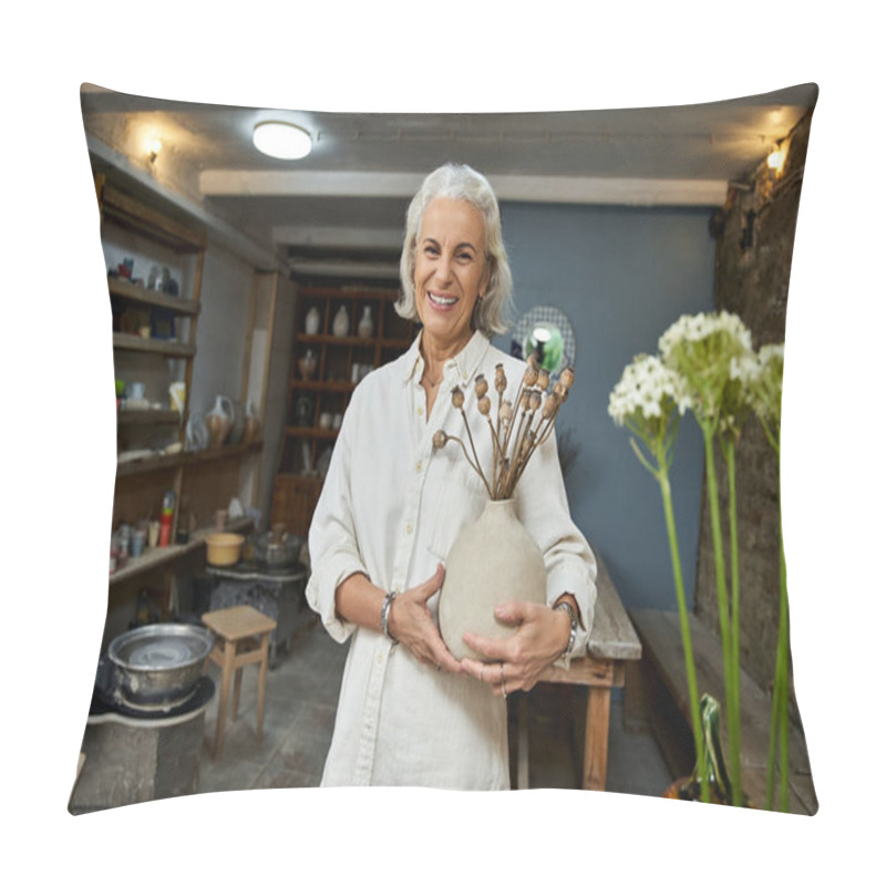 Personality  A Cheerful Mature Woman Holds A Handmade Vase, Displaying Creativity In Her Pottery Studio. Pillow Covers