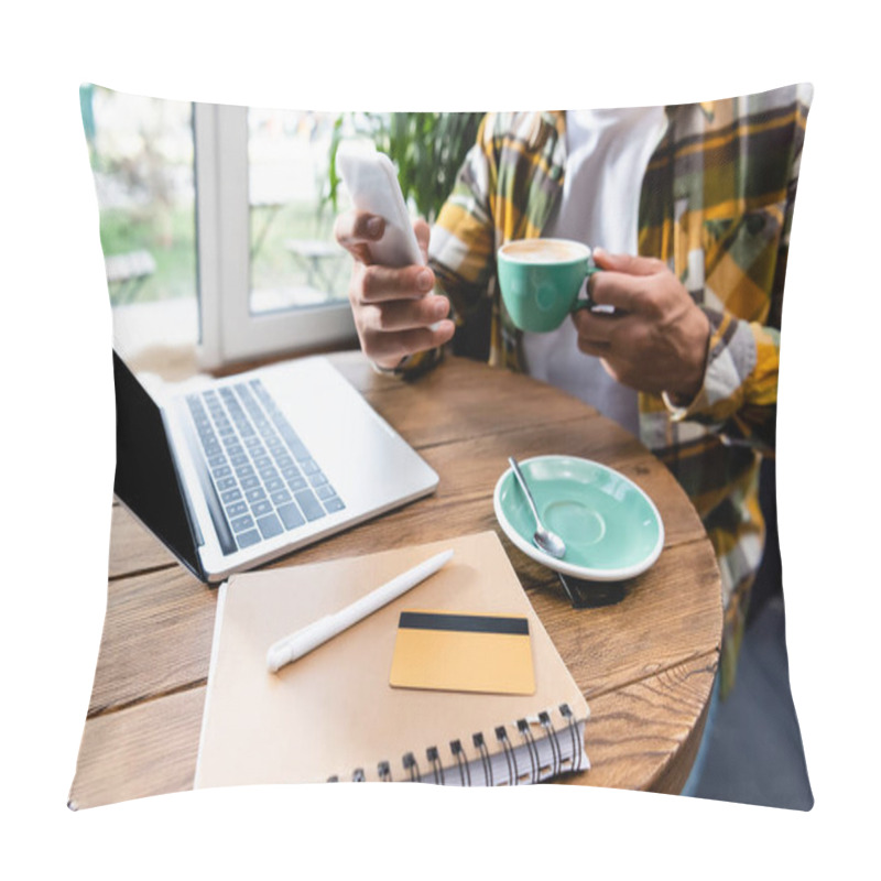 Personality  Cropped View Of Freelancer Chatting On Smartphone And Holding Cup Of Coffee Near Laptop, Notebook And Credit Card In Cafe, Blurred Background Pillow Covers