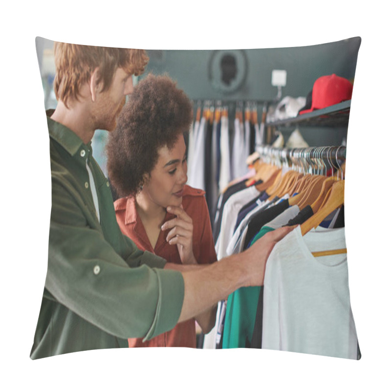 Personality  Smiling Young African American Craftswoman Looking At Clothes On Hangers While Standing Near Redhead Colleague In Blurred Print Studio, Young Small Business Owners Concept  Pillow Covers