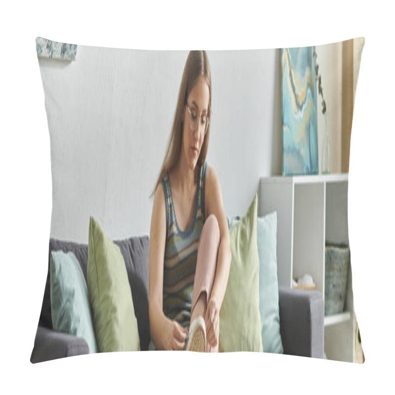 Personality  A Young Woman With A Prosthetic Leg Sits On A Couch In Her Modern Living Room, Tying Her Shoes. Pillow Covers