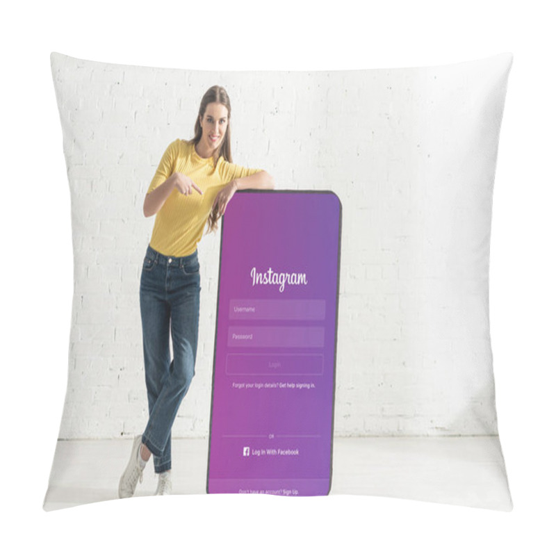 Personality  KYIV, UKRAINE - FEBRUARY 21, 2020: Smiling Woman Pointing With Finger At Model Of Smartphone With Instagram App Pillow Covers