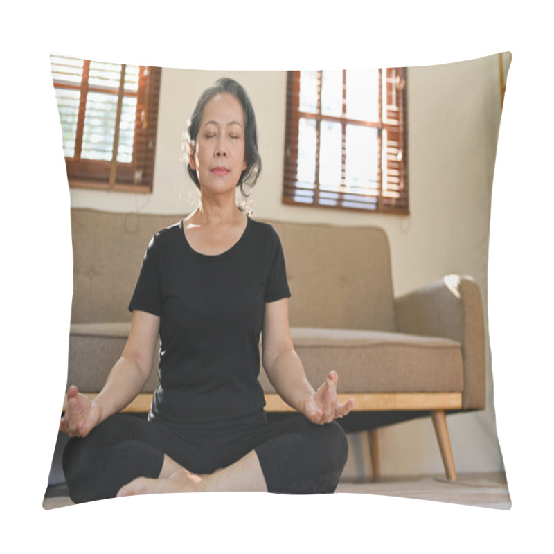 Personality  Calm And Relaxed 60s Retired Asian Woman In Gym Clothes Is Meditating In Her Living Room, Eyes Closed, Practicing Lotus Yoga Pose At Home. Pillow Covers