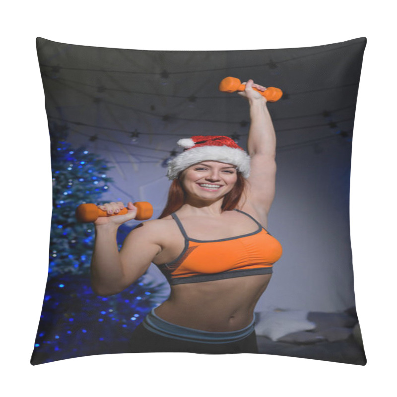 Personality  Beautiful Red-haired Female Athlete In A Santa Claus Hat Posing In A Dark Studio. Fitness Woman In Sportswear Holds A Dumbbell In Her Hands On The Background Of The New Year Tree. Pillow Covers