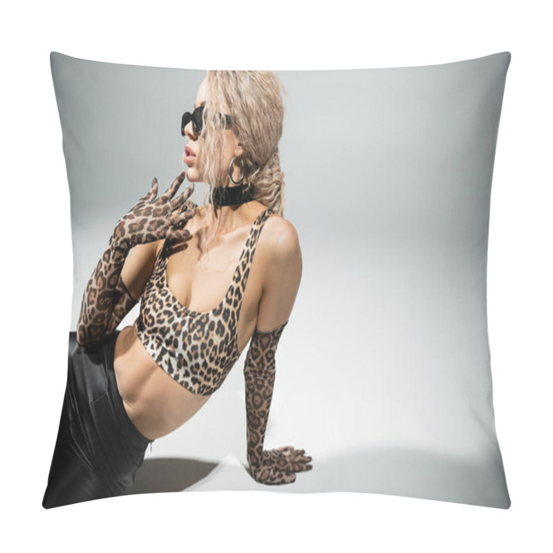 Personality  Fashion And Femininity, Sexy Woman With Slender Body, Dyed Ash Blonde Hair, In Dark Sunglasses, Animal Print Crop Top, Long Gloves And Black Latex Pants Sitting And Looking Away On Grey Background Pillow Covers