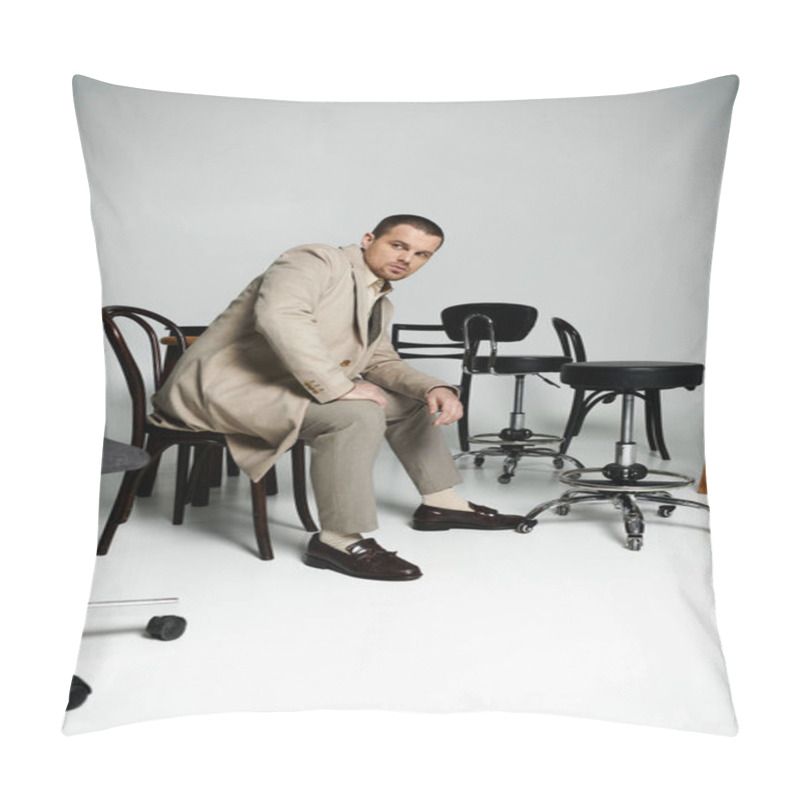 Personality  A Stylish Man Sits On A Chair, Surrounded By Other Chairs In A Studio Setting. Pillow Covers