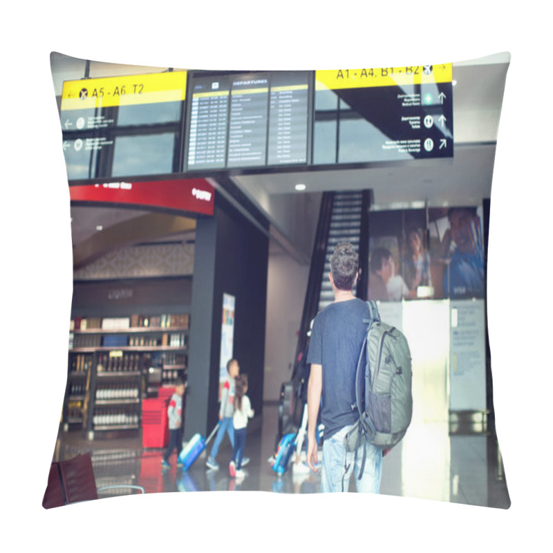 Personality  A Young Male Traveler With A Backpack In Casual Style Looks At The Information Board At The Airport. Getting Information About The Flight. Pillow Covers